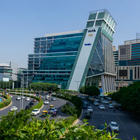 A modern, glass-fronted building with a distinctive sloping design, featuring 