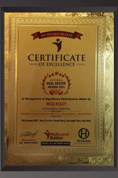 A gold ornate framed Certificate of Excellence from My Brand Better for the Global Real Estate Awards 2021, recognizing Mega Realty, Gurugram, Haryana as Property Consultant of the Year – Commercial/Residential category. The event was held on 10th October 2021 at Hotel The Park, Sansad Marg, Connaught Place, New Delhi. Endorsed by Hindustan and signed by Secretary Ms. Geeta Singh.