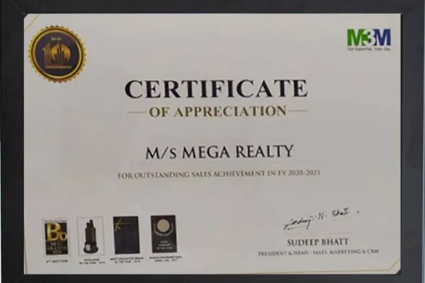 A white framed Certificate of Appreciation from M3M awarded to M/s Mega Realty for outstanding sales achievement in FY 2020-2021. Features award icons at the bottom including Best Brand of the Year, Developer of the Year, Best Residential Project, and Icon of Excellence. Signed by Sudeep Bhatt, President & Head – Sales, Marketing & CRM.