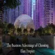 Illuminated geodesic dome clubhouse at Elan Empire surrounded by high-rise towers lit in purple at dusk, with text "The Business Advantage of Choosing Elan Empire".