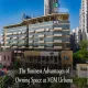 Aerial view of M3M Urbana commercial complex in Gurgaon with M3M and Urbana signage on the facade, overlaid with the text "The Business Advantages of Owning Space at M3M Urbana".