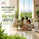 Godrej Air Gurgaon blog banner showing a family sitting on the floor of a bright, airy living room surrounded by indoor plants, with large windows overlooking lush greenery and a cityscape, an air purifier beside the sofa, and text overlay reading "Why Godrej Air Appeals to Homebuyers Seeking a Healthier Lifestyle" with tagline "Breath Better. Live Better." and the Godrej logo in the top left.