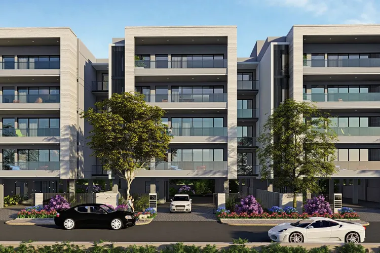 The exterior view of DLF Royale Residences, featuring a modern grey facade with multiple balconies, large windows, and lush purple and green landscaping at the entrance, with two luxury cars parked on the street.