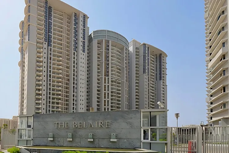 The main entrance to DLF The Belaire in Gurugram, featuring a large stone sign with 
