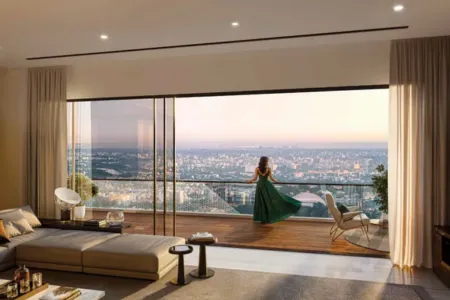 AIPL Riviera – Elegant Living Room with Sunset Balcony View Stylish living room at AIPL Riviera opening to a balcony with sunset cityscape and person in green dress