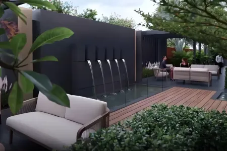 Birla Arika Outdoor Lounge with Water Wall and Garden Ambience Elegant outdoor lounge at Birla Arika with water wall, cushioned seating, and lush greenery