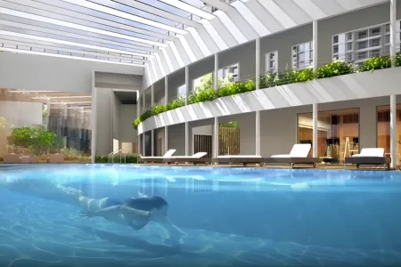 Birla Arika Indoor Pool with Skylight and Lounge Deck Spacious indoor pool at Birla Arika with skylight roof, lounge chairs, and modern architecture