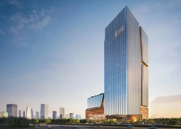 Landmark One Tower Daytime View with Copper-Accented Podium Daytime view of the tall fluted glass Landmark One tower with a bronze/copper-clad podium base, city skyline in the background, and a landscaped road with passing cars in the foreground.
