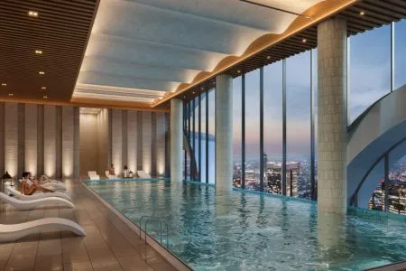 Origen Realty The Oryza - Luxury Indoor Swimming Pool with Skyline Views Architectural rendering of an indoor heated swimming pool at Origen Realty The Oryza with poolside lounge chairs, wave-pattern ceiling, and high-rise cityscape views.