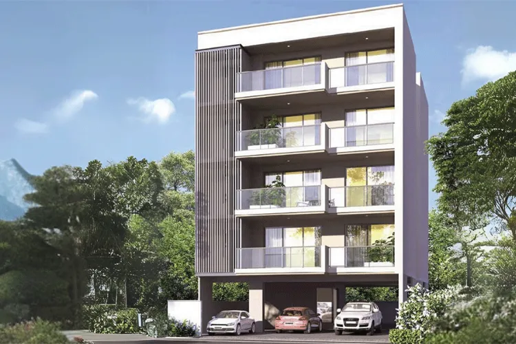 A modern residential building at DLF Amaltas Drive, Gurugram, showcasing contemporary architecture, spacious balconies, and stilt parking, surrounded by lush green landscaping.