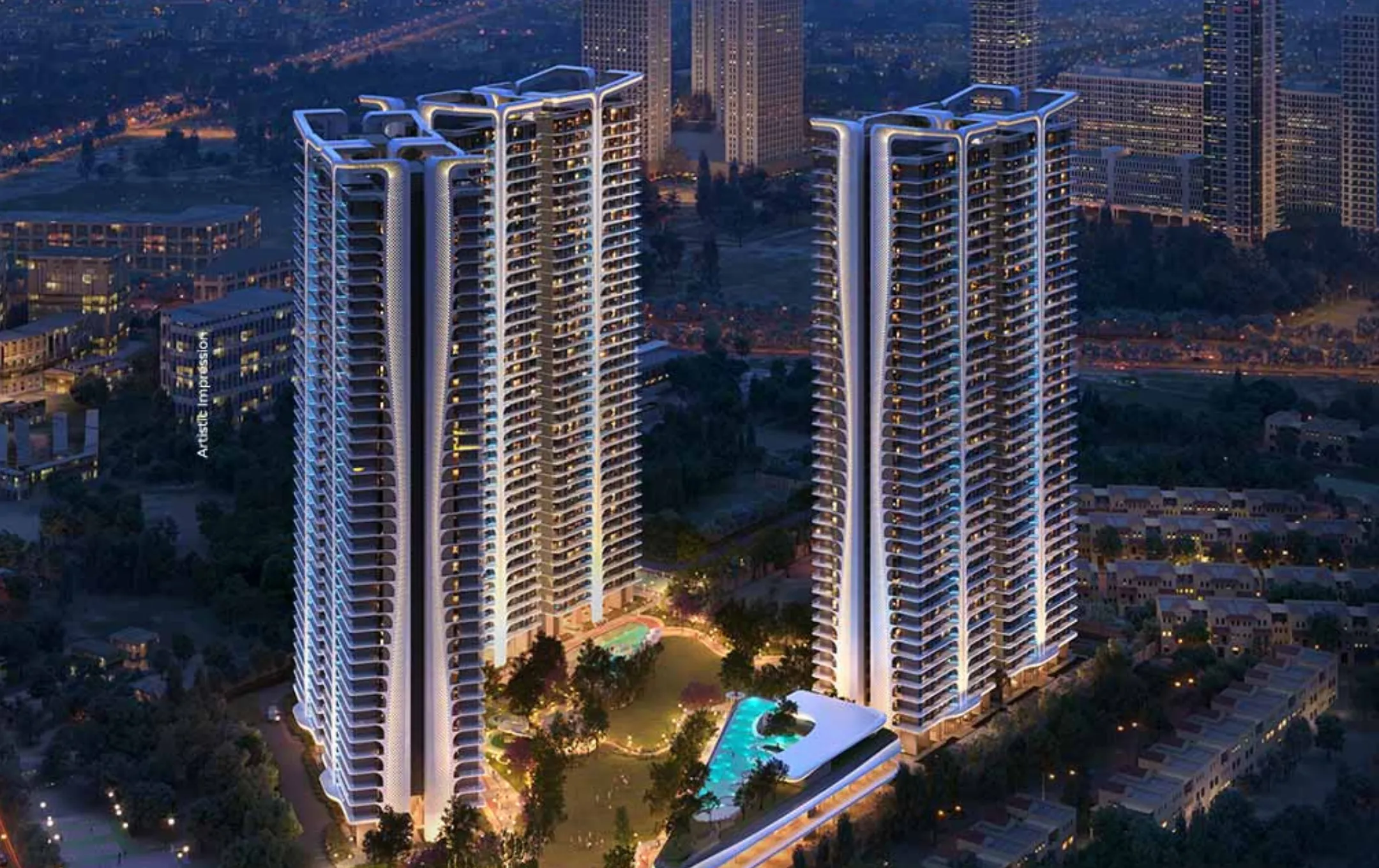  Aerial view of two futuristic, illuminated high-rise residential towers of Smart World The Edition at night, with intricate architectural details, lush landscaping, and sparkling swimming pools, set against a dark city skyline.