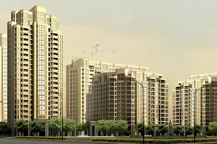 An aerial view of Vipul Greens, a large residential society in Sector 48, Gurgaon. The image shows multiple high-rise apartment towers with a modern design, surrounded by extensive landscaped gardens, lush green lawns, and recreational areas. Amenities such as a swimming pool, jogging tracks, and sports courts are visible, emphasizing the community's focus on a healthy lifestyle and open spaces. The image highlights the project's well-planned layout and serene environment.